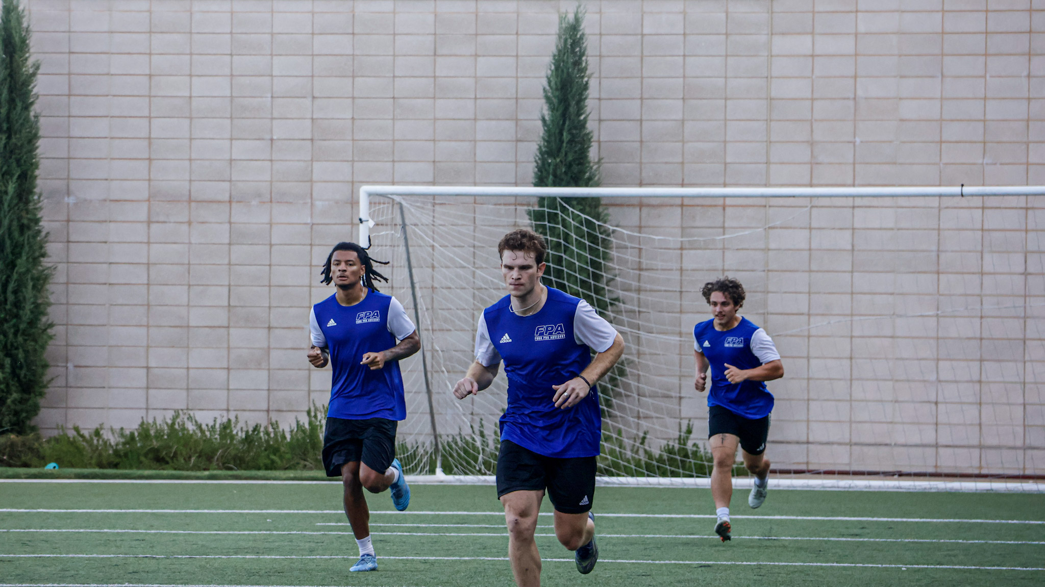 Players running a conditioning block on the indoor turf at EXOS.
